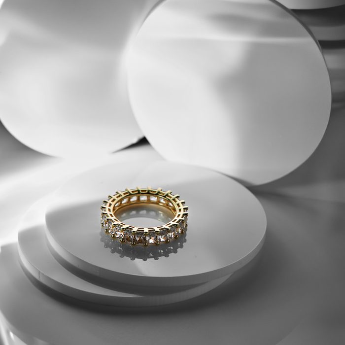 Diamond and gold ring on abstract background