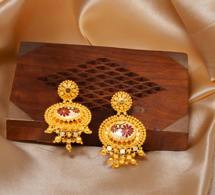 Gold earrings on silk background